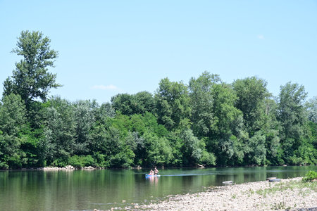 Beautiful summer landscape with a river and people on a kayakの写真素材
