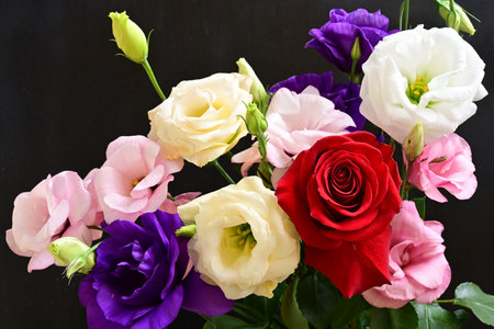 Bouquet of eustoma and roses on black background.の写真素材
