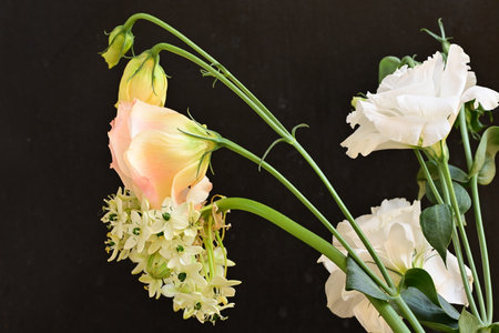 Bouquet of eustoma flowers on a black background.