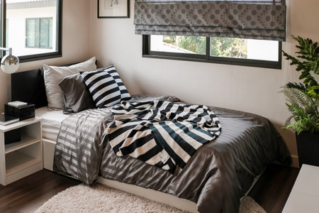 The master bedroom has a balcony. There were white sheets, gray blankets, several brown pillows and...