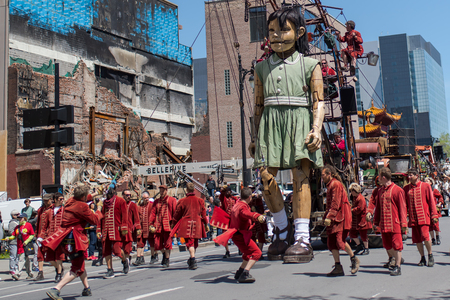 Montreal, Canada - May 20, 2017: The Little Girl-Giant presented by Royal de Luxe takes a walk on Viger Avenue to celebrate the 375th birthday of the city.のeditorial素材