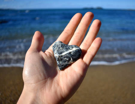 Holding a Heart Shaped Rock at the Beach