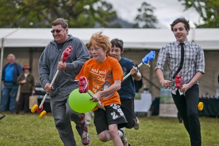 MARYSVILLE, VICTORIA, AUSTRALIA - November 2: A group of men and boys compete for first place in a hobby horse race at the Marysville Sparkling Wine Festival, November 2, 2010.  The Marysville Sparkling Wine Festival is held in Marysville Victoria, Austraのeditorial素材