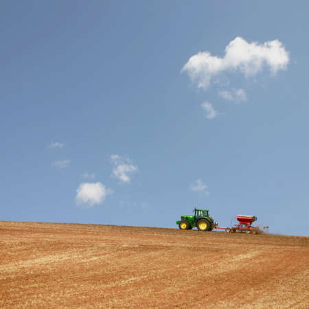 Farm Tractor Working in the Field with a Blue Sky