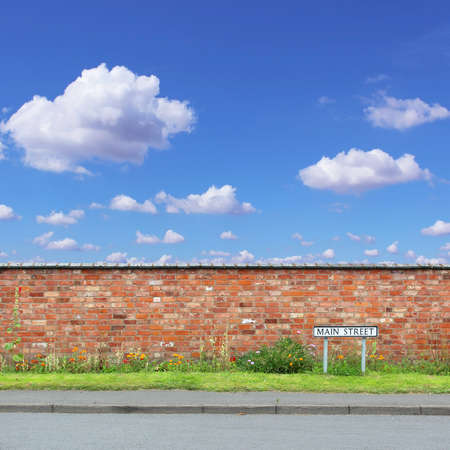 Red Brick Wall with a Main Street Sign and Sidewalk