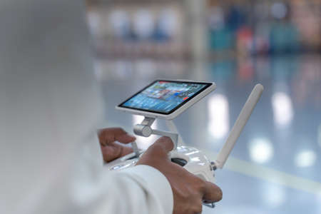 Drone camera operator surveying over a smart factory , industrial facility enabling IOT, tracking goods and inventory, logistic mapping in a futuristic world.の写真素材