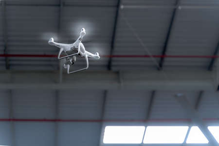 Flying drone camera surveying over a smart factory , industrial facility enabling IOT, tracking goods and inventory, logistic mapping in a futuristic world.の写真素材