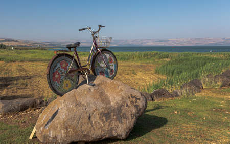 Landscape View of the sea of Galilee and mountains in the horizon in front of a cycle on a rockの写真素材