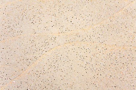 Golden sand beach background with bubbles and water flow tracesの写真素材