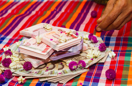 Dowry is Thai cash, used as a free gift to the bride's parents. Or for the spouse to use in a new family. Many 100,500,1000 baht banknotes scatter for the auspicious life and bless the family.の写真素材
