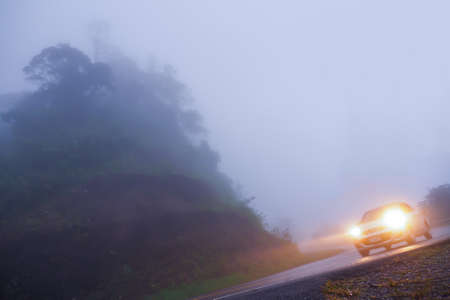 Driving in dense fog in remote mountainous areas with poor visibility often leads to frequent accidents. Can not see cars and routes.の写真素材