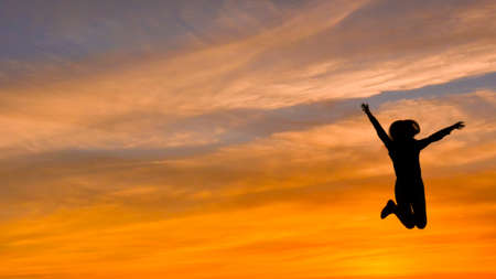 Jumping Woman At Sunset, Silhouettes, Freedom And Happinessの写真素材