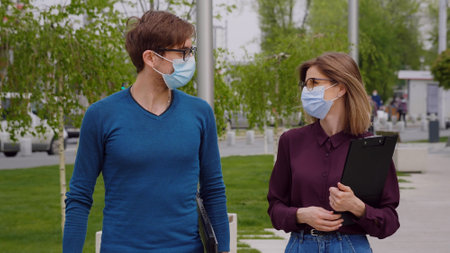 Entrepreneur Man and Woman talking or Conversation Outdoor in City as Business Communication Concept. Young managers wearing mask pandemic period.の写真素材