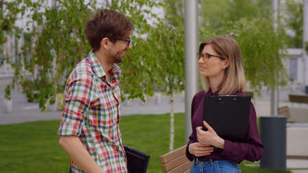 Two college students meeting and talking on campus, in a park. Exam period.Having serious conversationの写真素材
