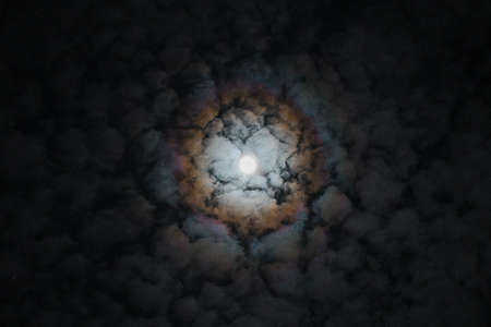 Surreal full moon with blurry rainbow clouds reflections of super moon producing rainbow on the surrounding clouds magic mystical moon on February 2018 Special sky colors of moon.の写真素材