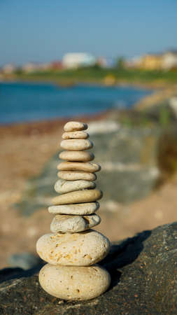 Balanced stone pyramid on sand on beach. Holidays vacation sightseeing.