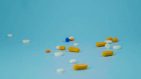 Medical background with pills and capsule on blue background. Assorted pharmaceutical medicine pills, tablet. Heap of various assorted medicine tablets and pills different colors. Health care.の写真素材
