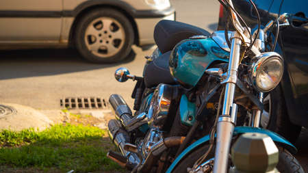 Parked metallic blue motorbike on green grass in townの写真素材