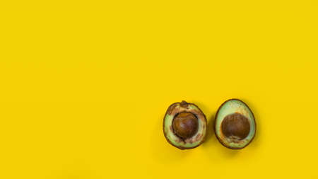 Two Half Bad Avocado.The seed avocado and the inside is visible. Rotten Avocado on yellow background Yellow Copy space.の写真素材