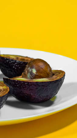 Bad Avocado Close up Vertical Photo. Ugly Tropical fruits. Contaminated Avocado half. Necomestibile Fruits. Bad Vegan food. Overripe Avocado.の写真素材