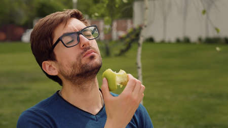 Employee Taking Break Work. Young man Eating a apple as snack. Heathy food Concept.の写真素材