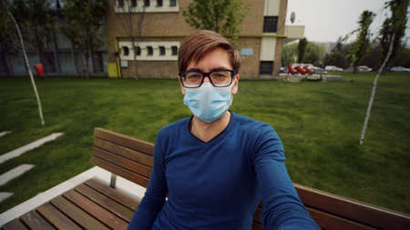 Point of view shot of man wear mask making online video call holding device with camera talking and...