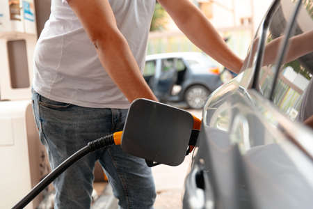 Hand Man Refill and filling Oil Gas Fuel at station. Gas station - refueling. Car fill with gasoline...