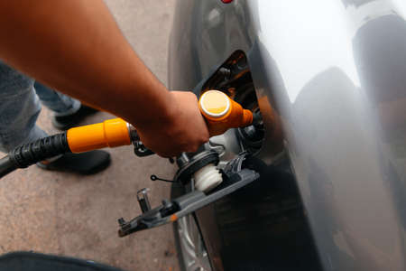 Hand Man Refill and filling Oil Gas Fuel at station. Refueling automobile with gasoline or diesel with a fuel dispenser. Fuel businessの写真素材
