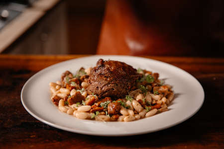 Professional chef cooking in kitchen. Tasty dish with beef steak and beans.の写真素材