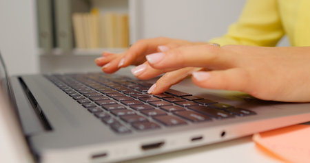 Hands of professional business woman typing on laptop notebook keyboard. Working remotely from home office on software apps. Technology concept.の写真素材