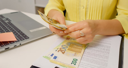 Female hands counting Euro banknotes large amount of cash money. Euro currency money, cash payment from income or family budget savings, investment.の写真素材