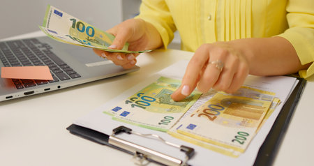 Female hands counting cash Euro banknotes selecing hundreds from two hundreds bills. Family budget strategy. Currency concept.の写真素材