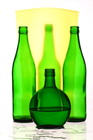 four glass bottle and yellow backgroundの写真素材
