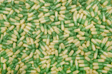 Filled background of green-yellow capsulesの写真素材
