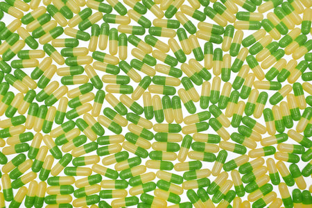 Filled background of green-yellow capsulesの写真素材