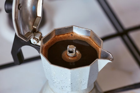 A geyser coffee maker on a gas stove produces a portion of coffeeの写真素材
