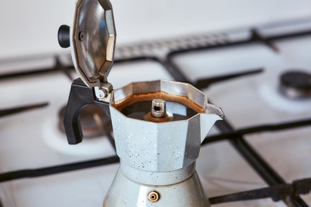 A geyser coffee maker on a gas stove produces a portion of coffeeの写真素材