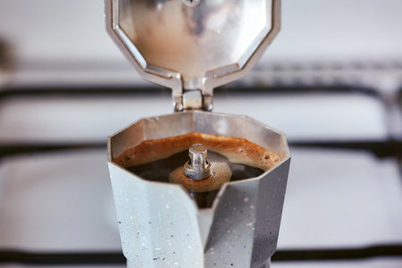 A geyser coffee maker on a gas stove produces a portion of coffeeの写真素材