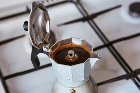 A geyser coffee maker on a gas stove produces a portion of coffeeの写真素材