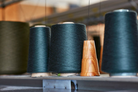 Three bobbins with industrial threads on conesの写真素材