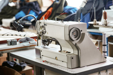 White sewing machine with threads nearby without workersの写真素材