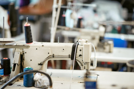 White sewing machine with threads nearby without workersの写真素材