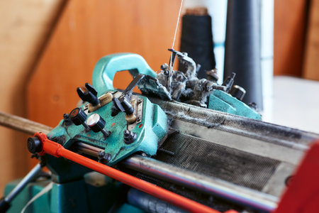 A small simple knitting machine with threads nearby without workersの写真素材
