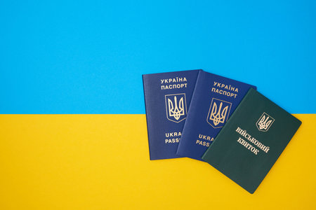 Ukrainian green military ID ticket on the Ukrainian national flag in the top view. Translation: "Military ID" and two blue Ukrainian IDsの写真素材
