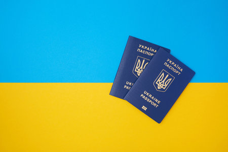 Two blue Ukrainian biometric passports on the Ukrainian national flag in the top viewの写真素材