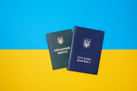Ukrainian green military ID ticket. Translation: "Military ID" and blue Ukrainian employment history Translation: "Employment history", on the Ukrainian national flag in the top view.の写真素材