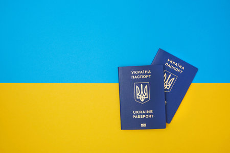 Two blue Ukrainian biometric passports on the Ukrainian national flag in the top viewの写真素材