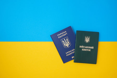 Ukrainian green military ID ticket on the Ukrainian national flag in the top view. Translation: "Military ID" and blue Ukrainian biometric IDの写真素材