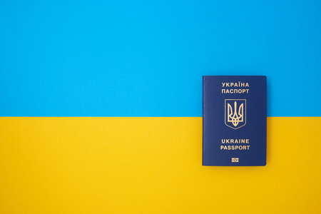 One blue Ukrainian biometric passport on the Ukrainian national flag in the top viewの写真素材