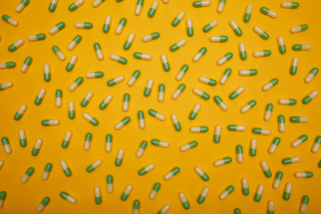 Filled background of green-yellow capsules which are located separately from each otherの写真素材